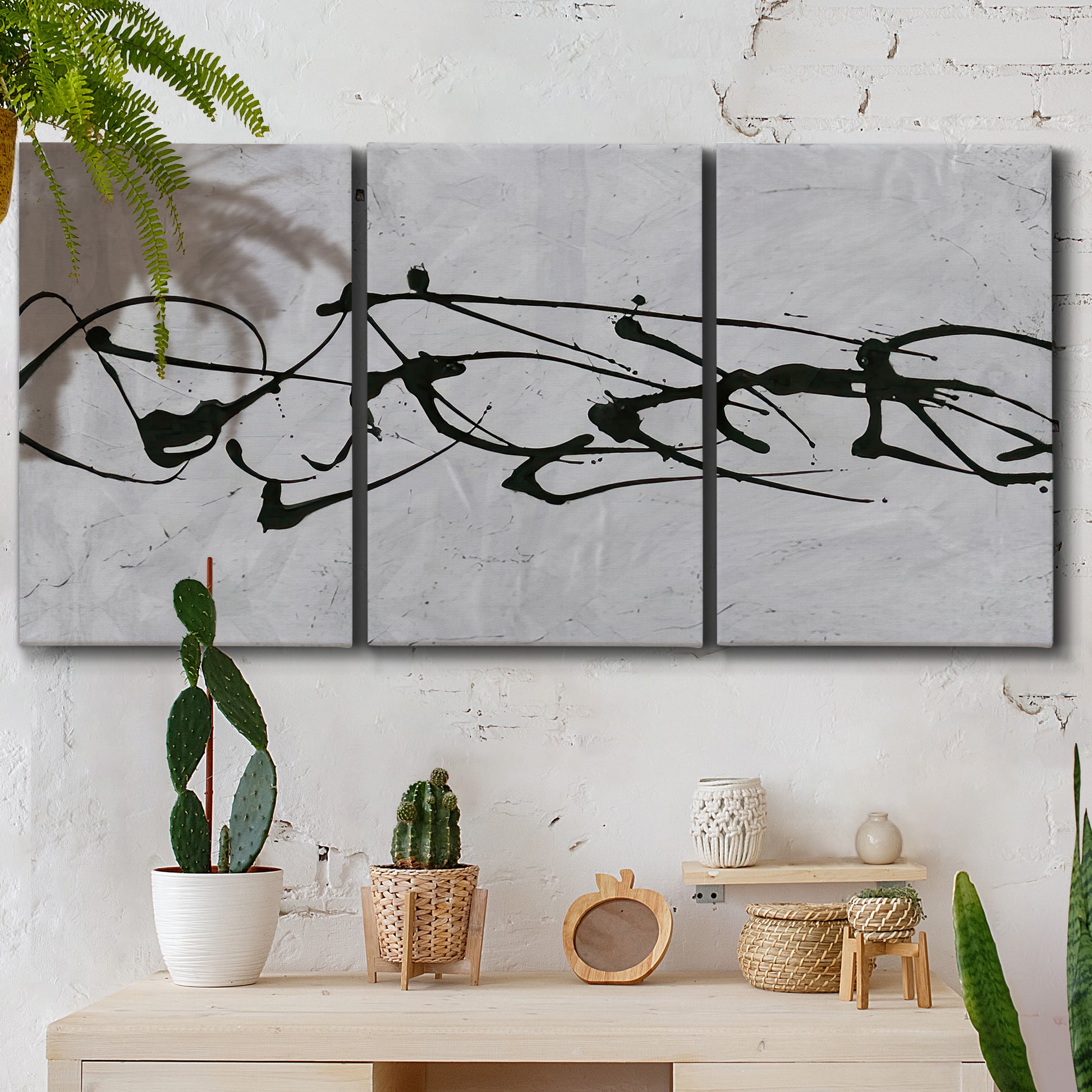 Three-panel canvas wall art featuring minimal abstract frequency lines, displayed in a boho-chic entryway above a console table.