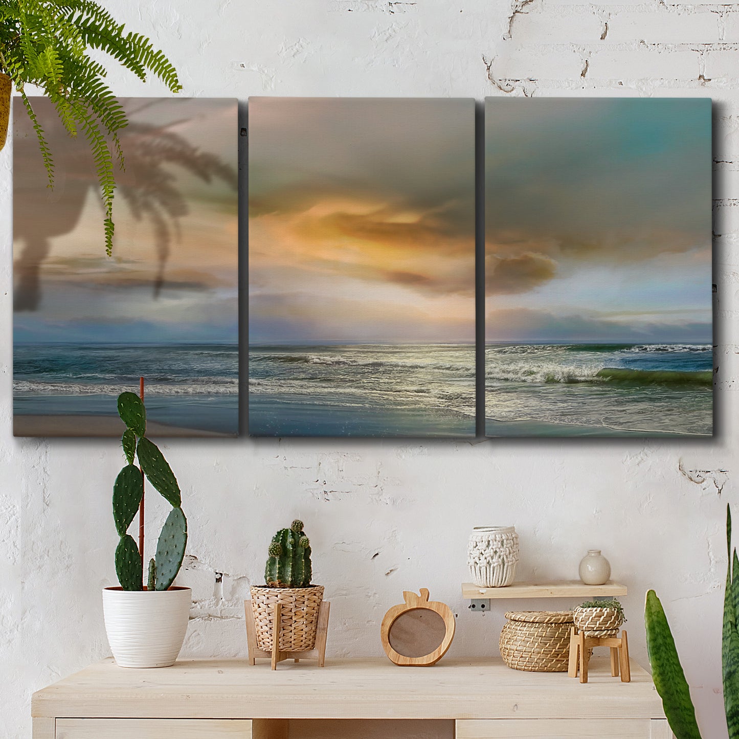 Three-panel canvas wall art featuring tranquil beach at sunset, displayed in a boho-chic entryway above a console table.