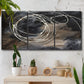 Three-panel canvas wall art featuring dark swirling abstract motion, displayed in a boho-chic entryway above a console table.