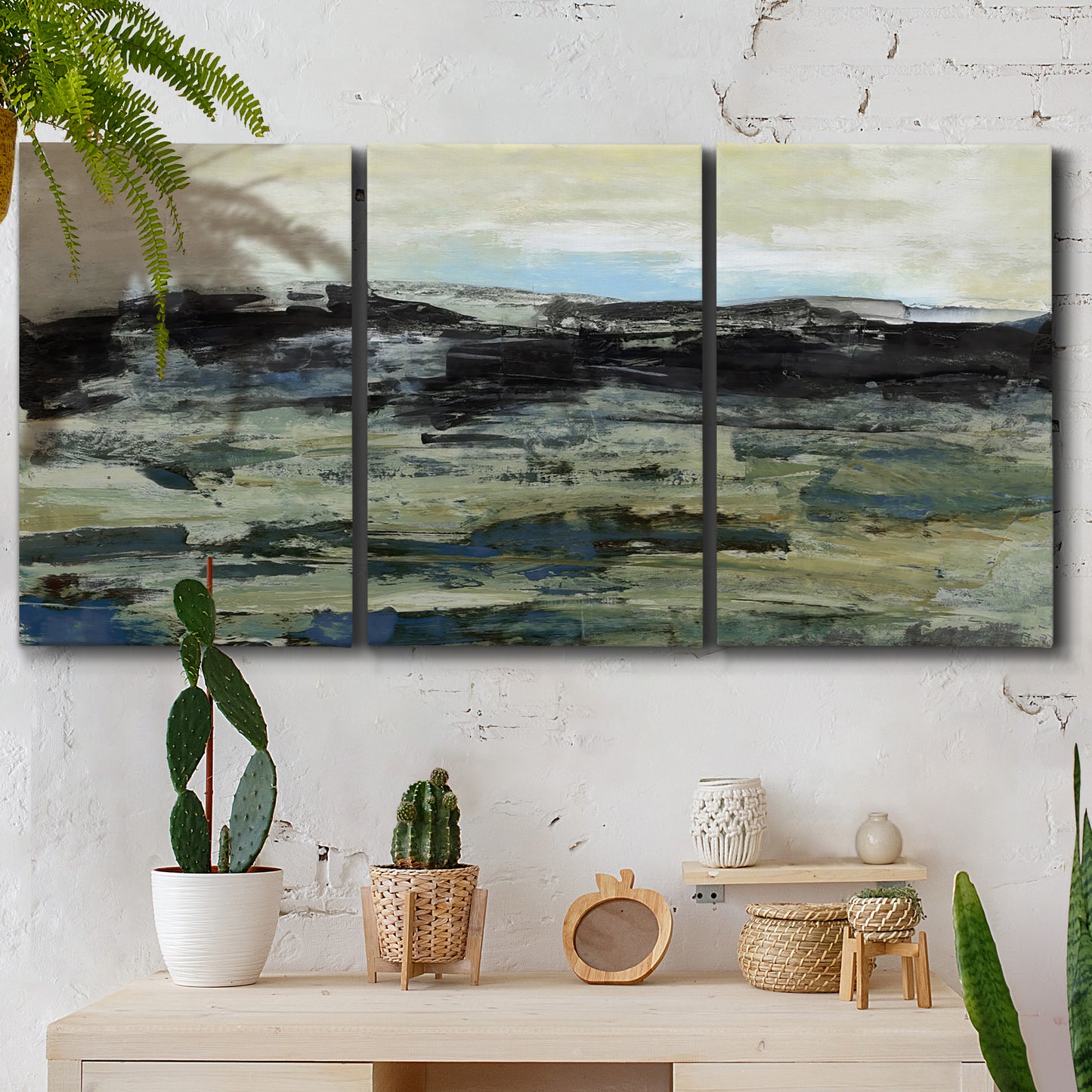 Three-panel canvas wall art featuring muted abstract landscape study, displayed in a boho-chic entryway above a console table.