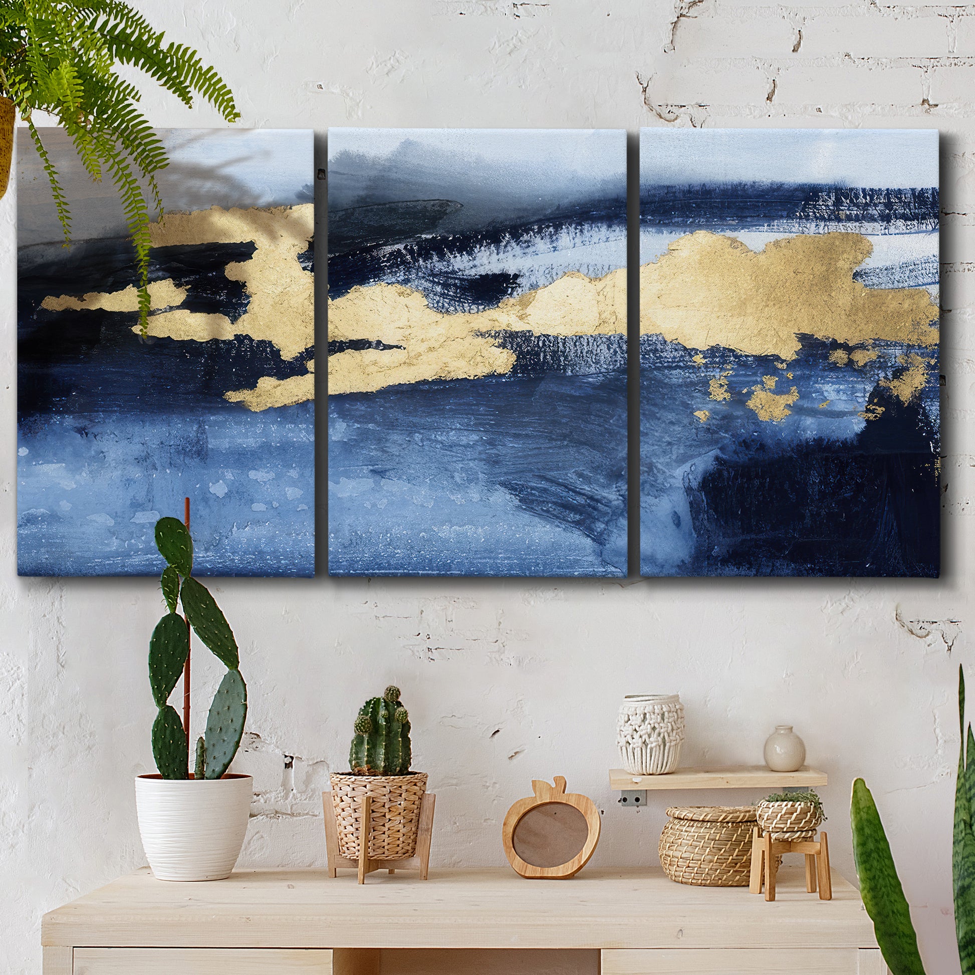 Three-panel canvas wall art featuring coastal shoreline with warm light, displayed in a boho-chic entryway above a console table.