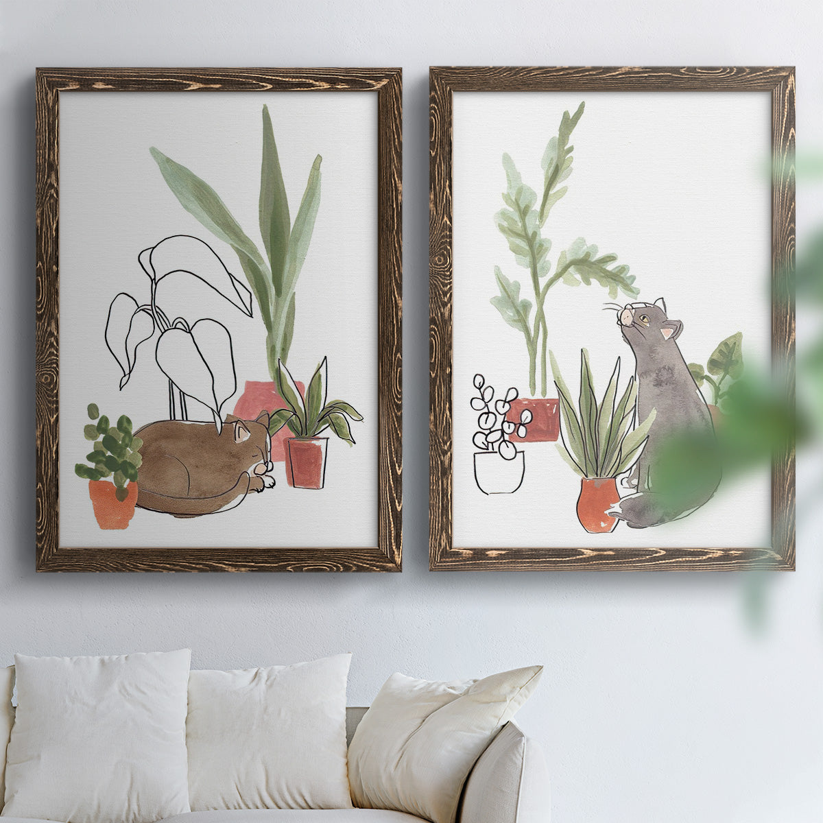 Set of two walnut barnwood framed canvas prints depicting curious felines, terracotta pots, succulents, and leafy stems arranged across two complementary compositions above a sofa in a bright living space.