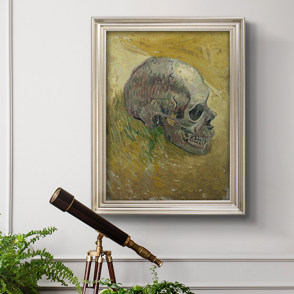 Profile skull study artwork by Vincent van Gogh in an ornate champagne frame displayed in a light-toned interior setting.