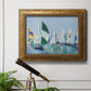 Coastal harbor watercolor painting in an ornate vintage gold frame displayed in a light-toned interior setting.