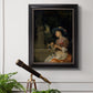 Classical interior scene of a woman weaving flowers by Godfried Schalcken in an ornate black frame with gilded inner detail displayed in a light-toned interior setting.