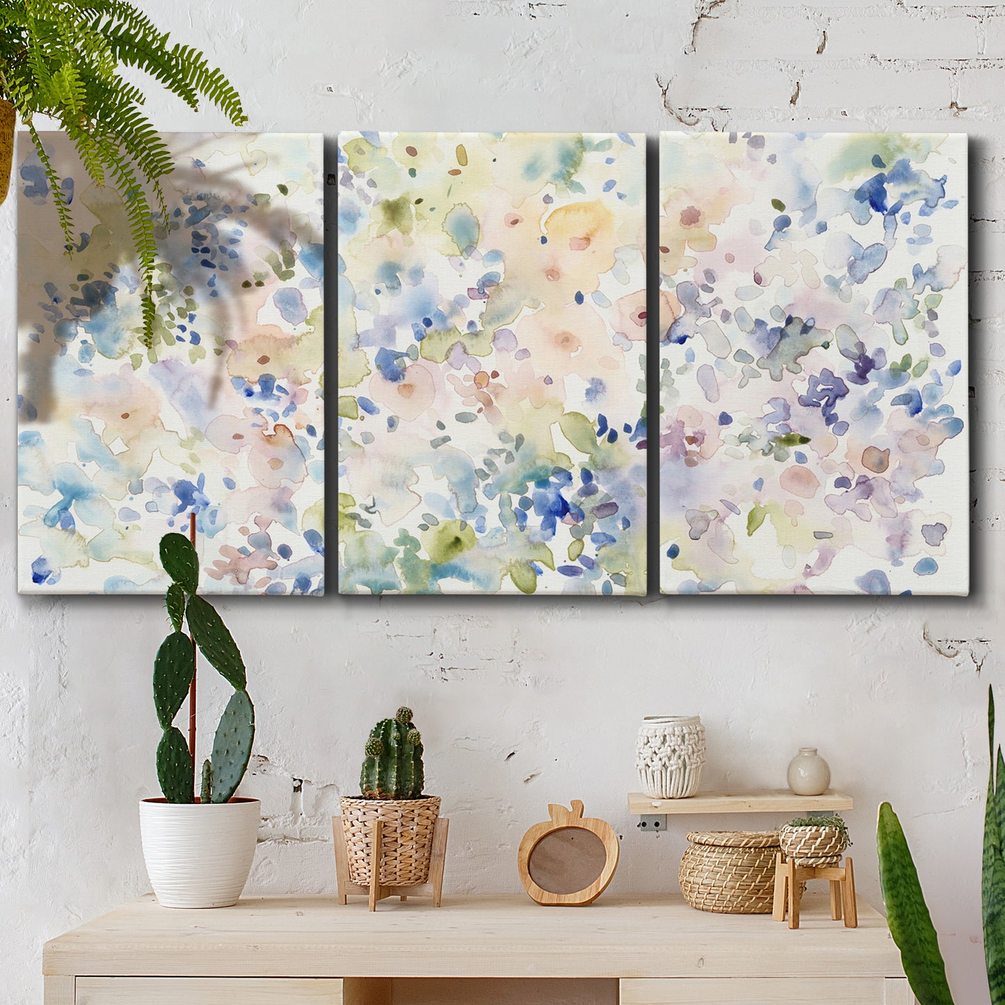 Three-panel canvas wall art featuring flowing abstract watercolor, displayed in a boho-chic entryway above a console table.