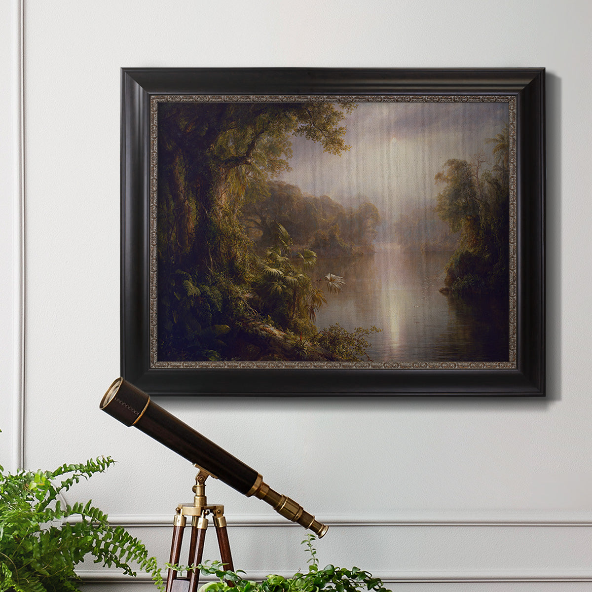 Luminous romantic landscape painting by Frederic Edwin Church in an ornate black frame with gilded inner detail displayed in a light-toned interior setting.
