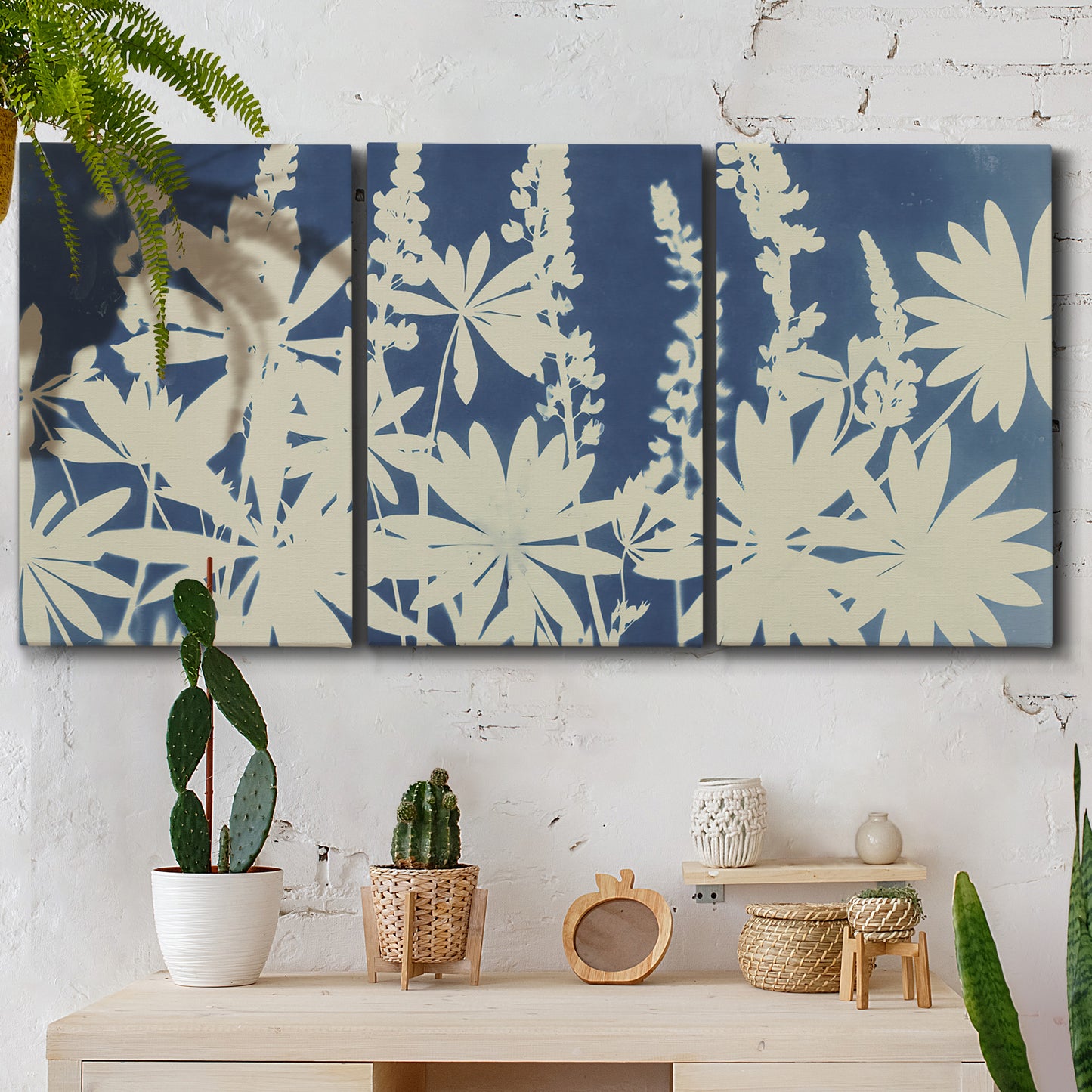 Three-panel canvas wall art featuring delicate lupine floral composition, displayed in a boho-chic entryway above a console table.