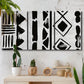Three-panel canvas wall art featuring geometric abstract forms merging pattern, displayed in a boho-chic entryway above a console table.