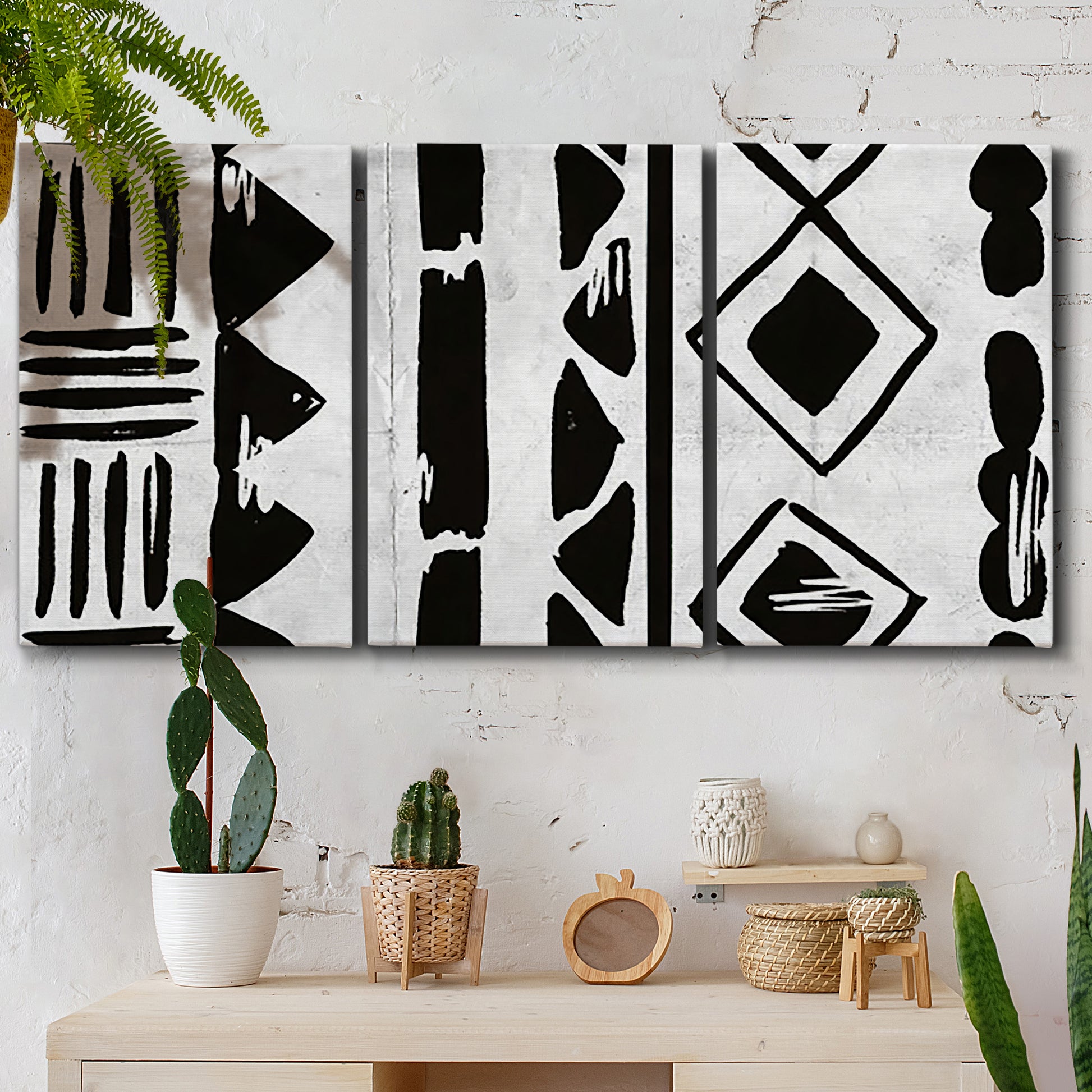 Three-panel canvas wall art featuring geometric abstract forms merging pattern, displayed in a boho-chic entryway above a console table.