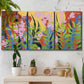Three-panel canvas wall art featuring bold colorful floral abstraction, displayed in a boho-chic entryway above a console table.