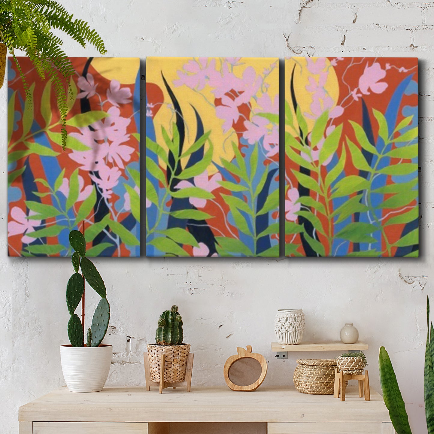 Three-panel canvas wall art featuring bold colorful floral abstraction, displayed in a boho-chic entryway above a console table.