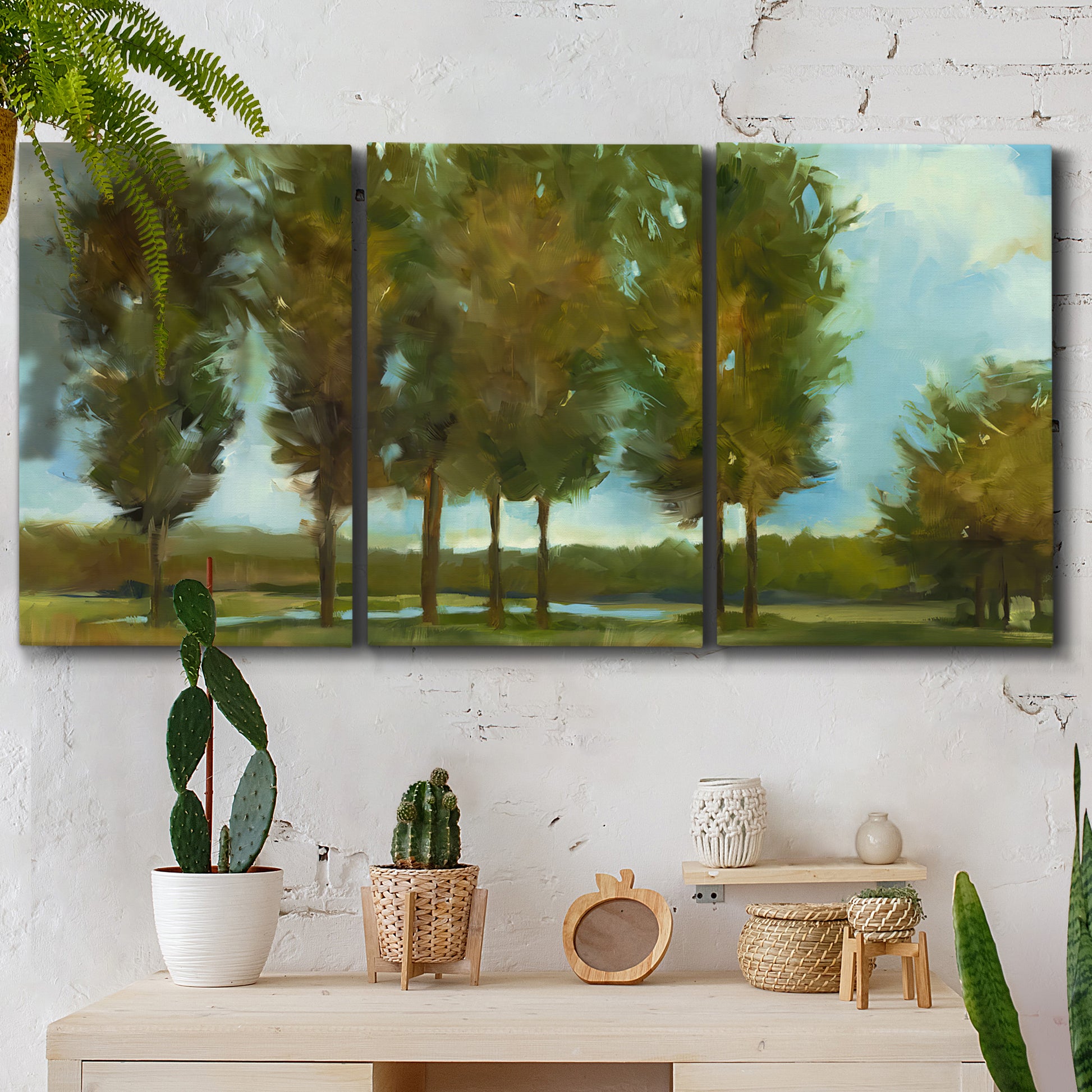 Three-panel canvas wall art featuring tall trees lining open landscape, displayed in a boho-chic entryway above a console table.