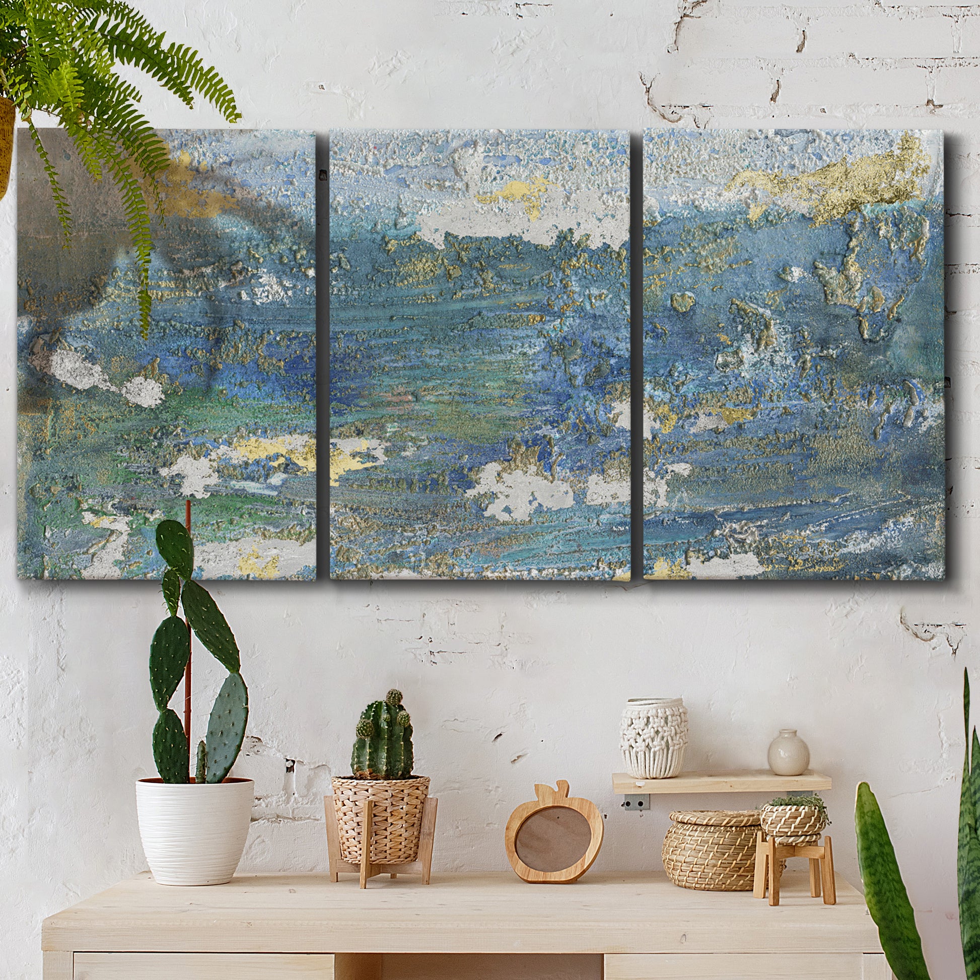 Three-panel canvas wall art featuring sparkling abstract sea surface, displayed in a boho-chic entryway above a console table.