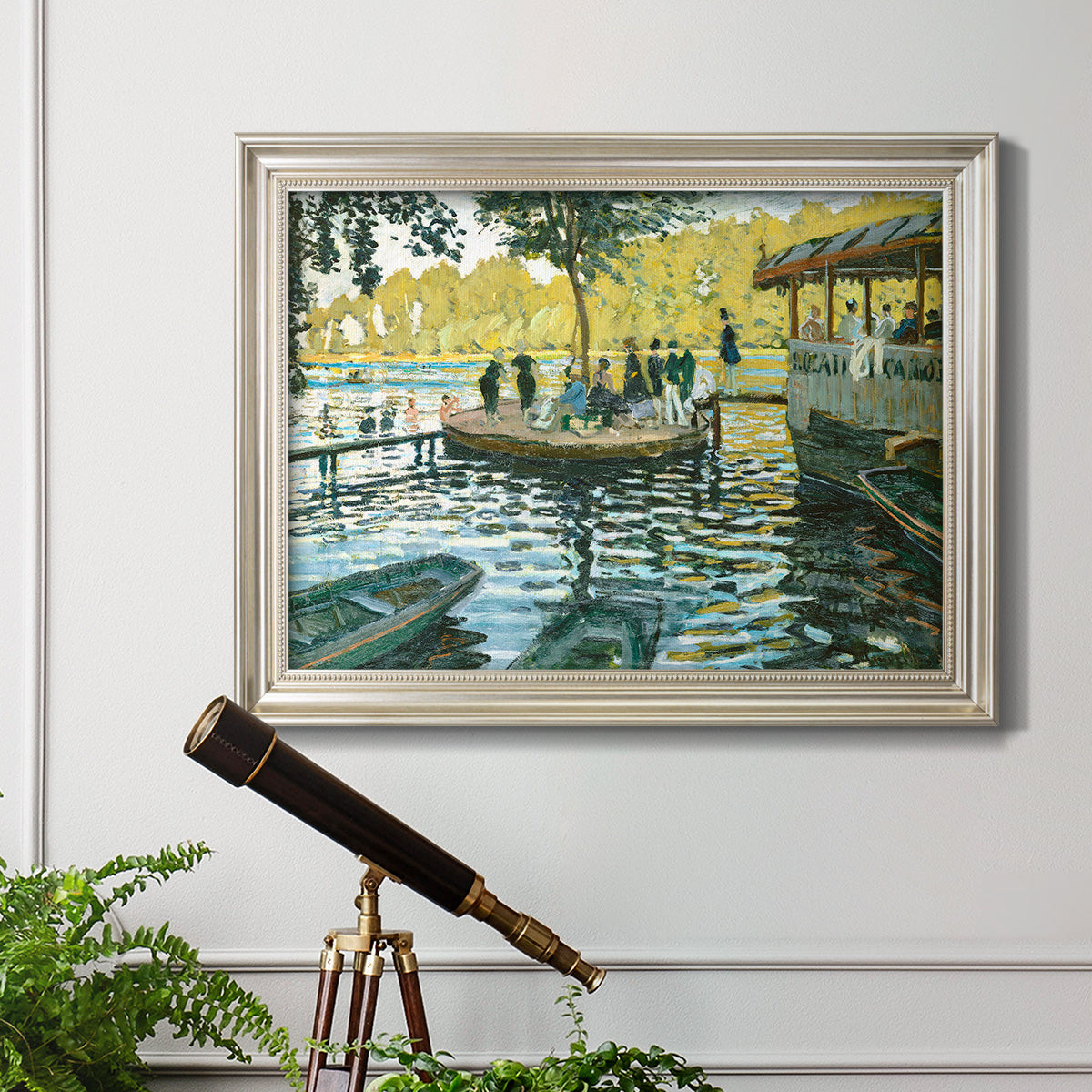 Impressionist riverside leisure scene by Claude Monet in an ornate champagne frame displayed in a light-toned interior setting.