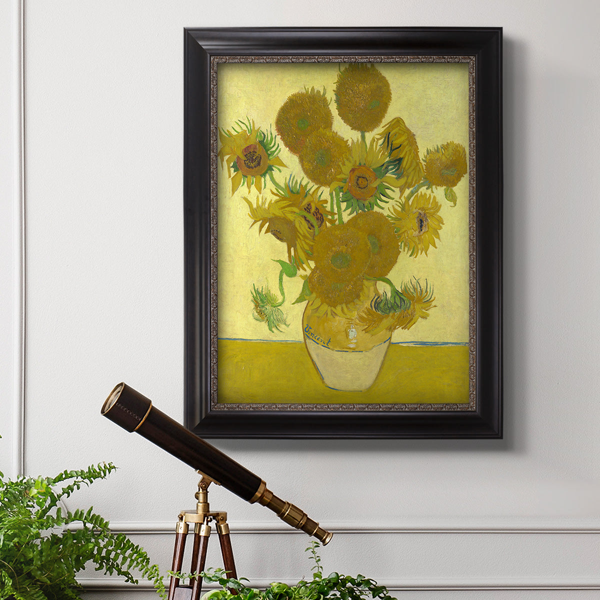 Impressionist sunflower still life painting by Vincent van Gogh in an ornate black frame with gilded inner detail displayed in a light-toned interior setting.