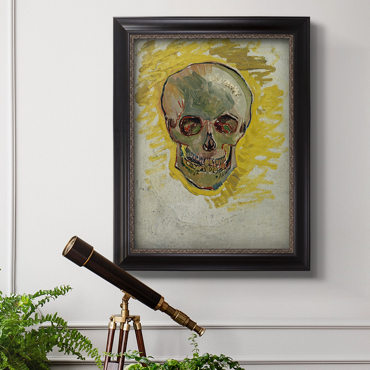 Expressive skull study painting by Vincent van Gogh in an ornate black frame with gilded inner detail displayed in a light-toned interior setting.
