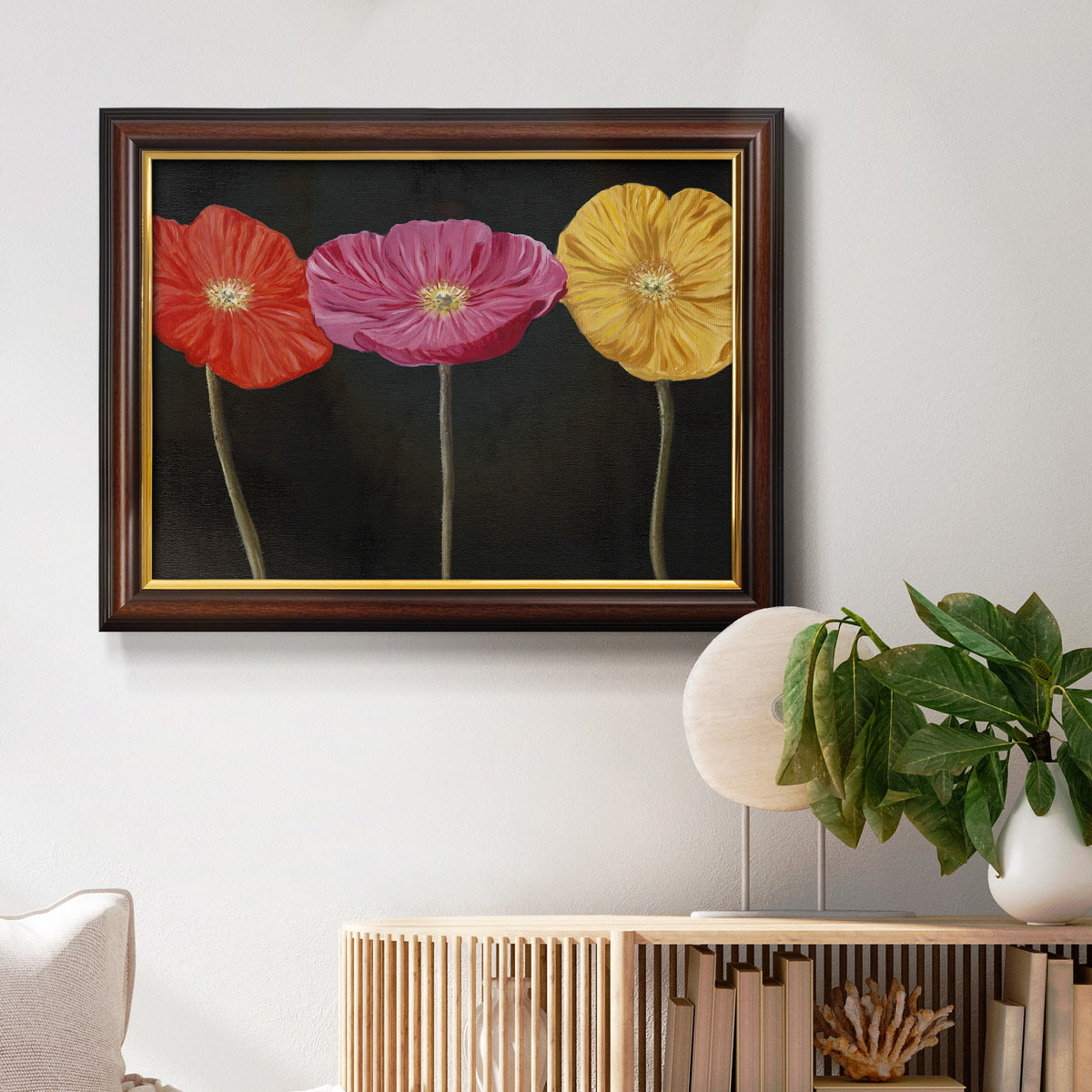 Contemporary poppy flower artwork in an ornate mahogany wood frame with gold liner displayed in a light-toned interior setting.