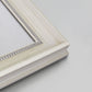 Detail of ornate weathered white frame.