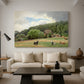 Canvas art print featuring a rural landscape with cows feeding on grass near buildings, displayed in a spacious living room