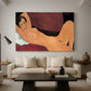 Canvas art print featuring a stylized female nude with elongated proportions resting on couch, displayed in a spacious living room