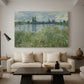 Canvas art print featuring a tranquil riverside scene with houses and vegetation, displayed in a spacious living room
