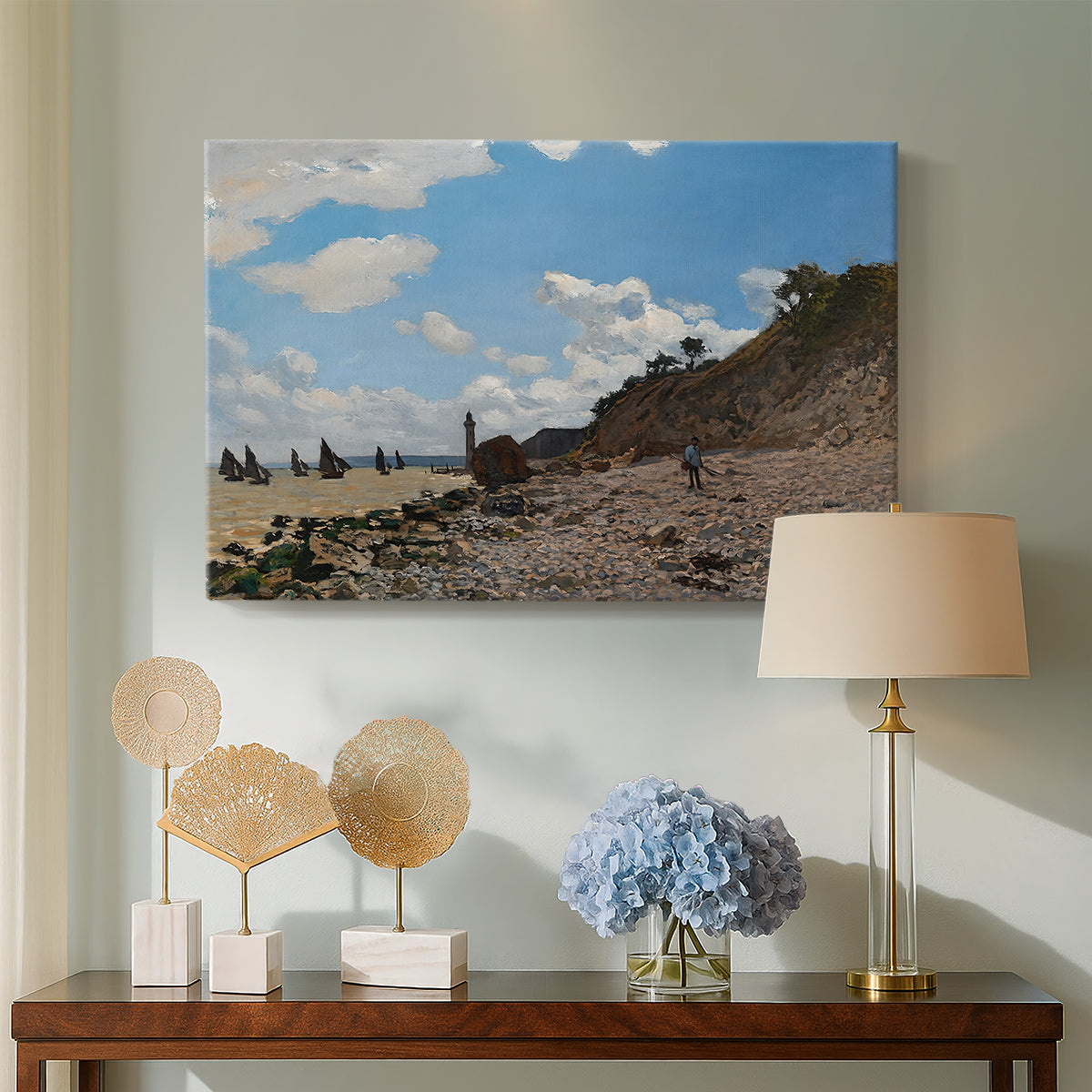 Canvas art print featuring a sandy beach with figures relaxing near water's edge, displayed above a styled console table