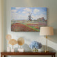 Canvas art print featuring an impressionist field of blooming tulips under bright sky, displayed above a styled console table