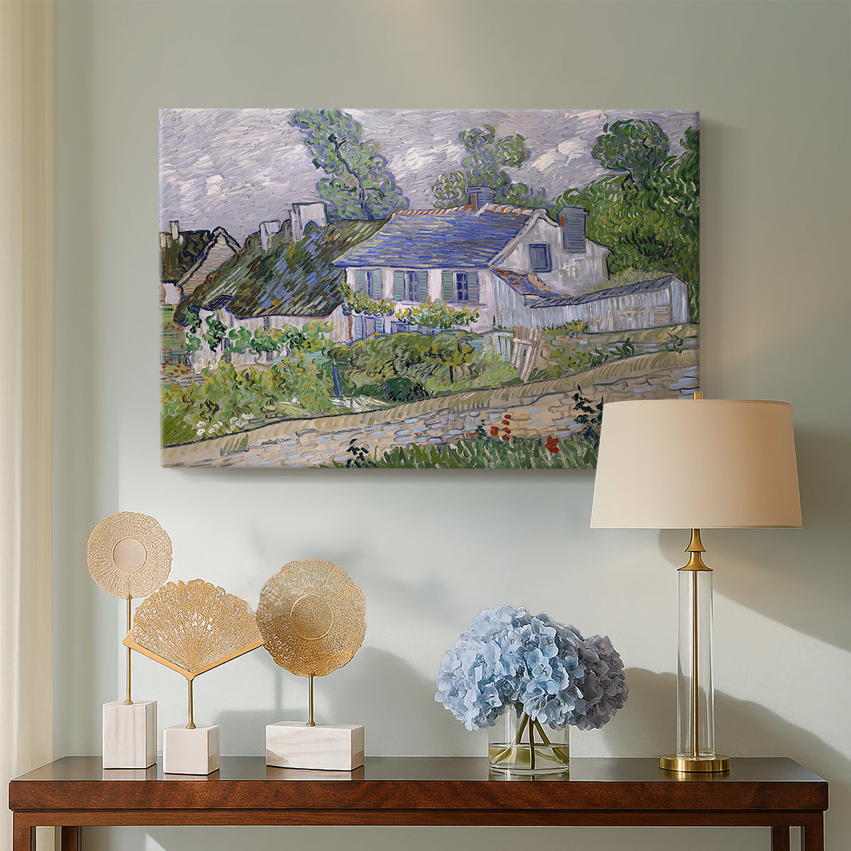 Canvas art print featuring a post-impressionist cityscape with rooftops and vegetation, displayed above a styled console table