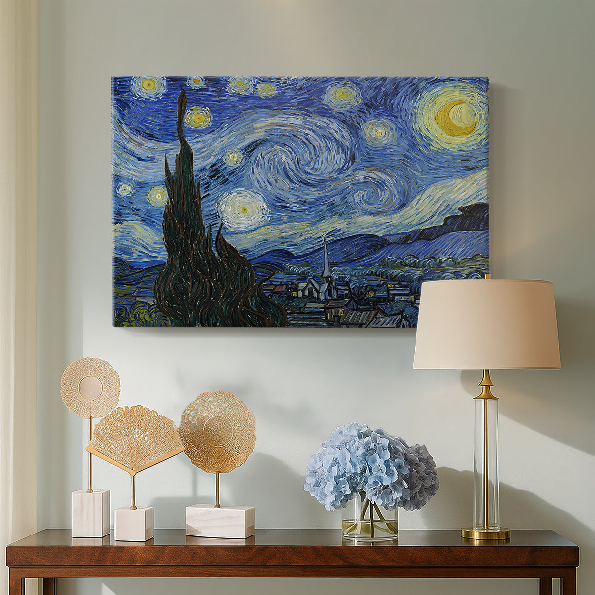 Canvas art print featuring a post-impressionist night scene with village beneath moving sky, displayed above a styled console table