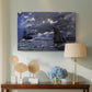 Canvas art print featuring a dramatic ocean scene with light reflecting across water at night, displayed above a styled console table