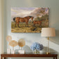 Canvas art print featuring a realistic depiction of several horses standing outdoors, displayed above a styled console table