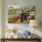 Canvas art print featuring a rustic village setting with people interacting in open space, displayed above a styled console table