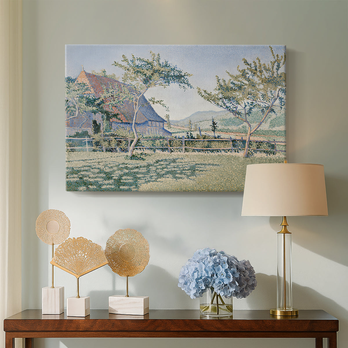 Canvas art print featuring a rural composition with houses and greenery, displayed above a styled console table