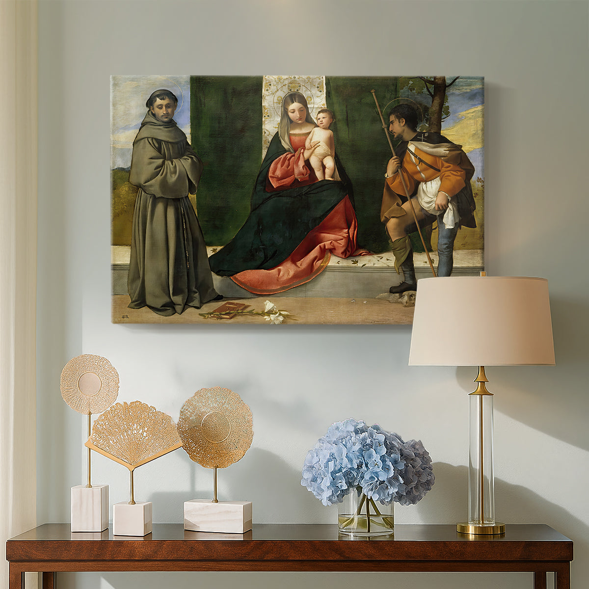 Canvas art print featuring a Renaissance image of mother and child flanked by saints, displayed above a styled console table