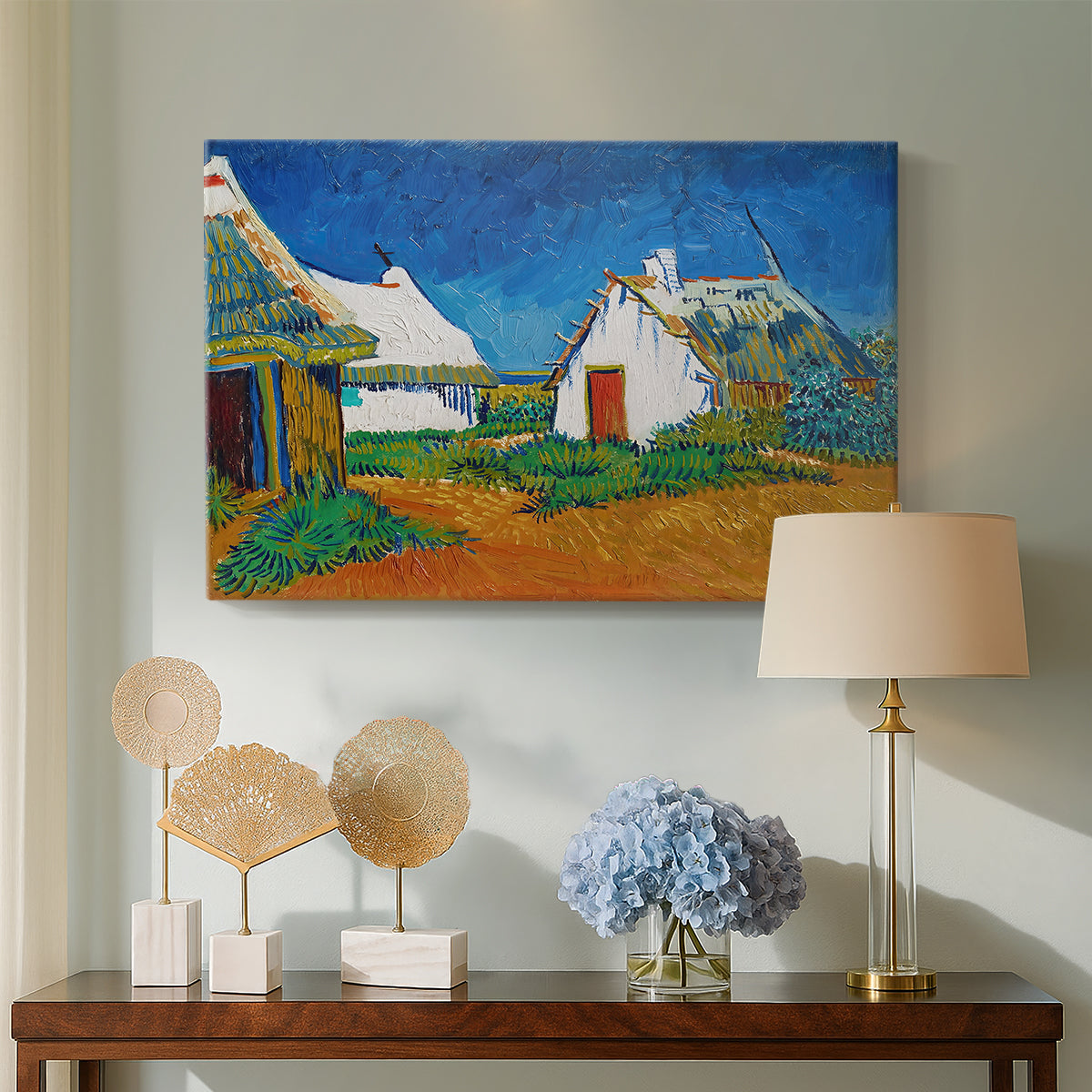 Canvas art print featuring a post-impressionist village composition with strong outlines, displayed above a styled console table