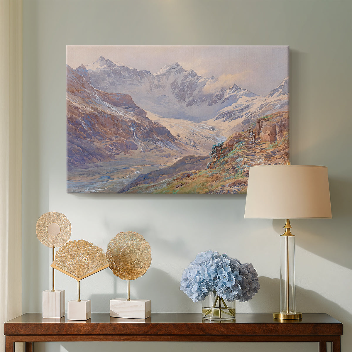 Canvas art print featuring a realistic depiction of high-altitude snowy peaks, displayed above a styled console table