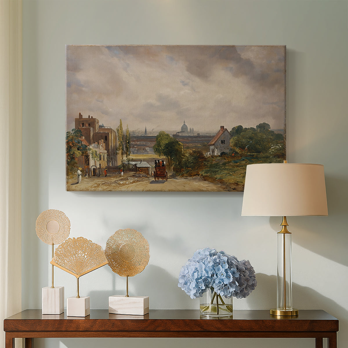 Canvas art print featuring a countryside scene with cottage, displayed above a styled console table