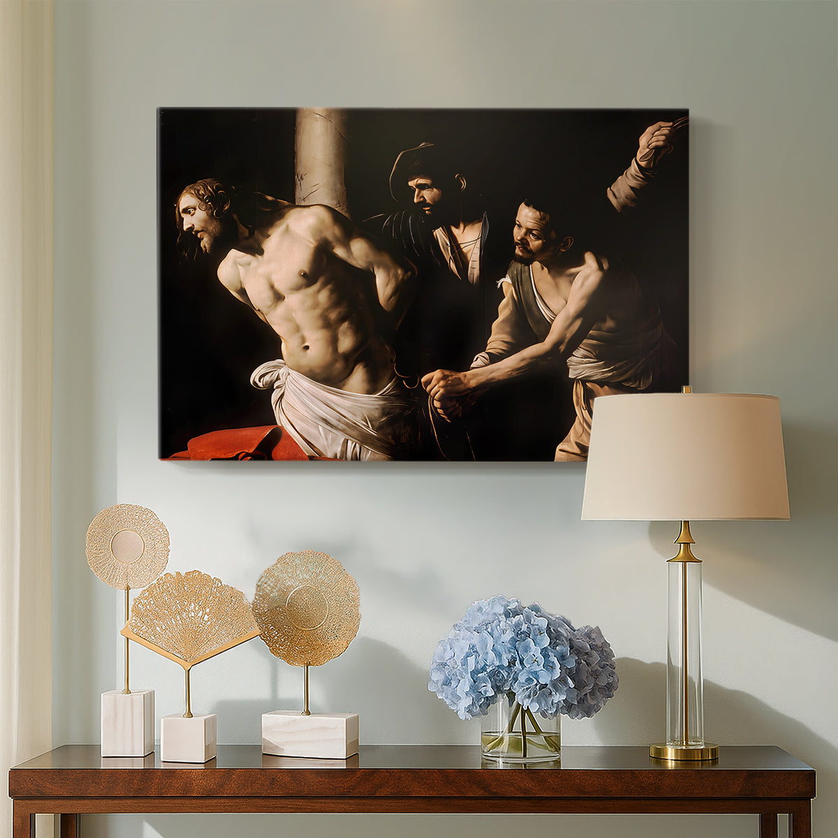 Canvas art print featuring a biblical depiction of men whipping Christ tied to pillar, displayed above a styled console table