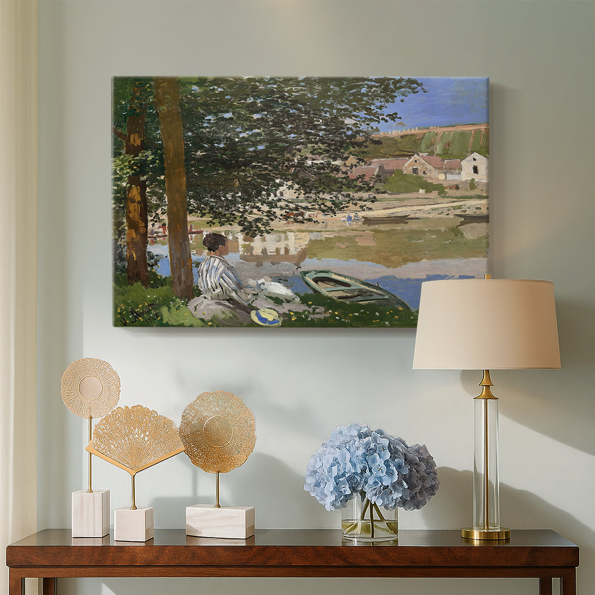 Canvas art print featuring an impressionist landscape with people relaxing along the Seine, displayed above a styled console table