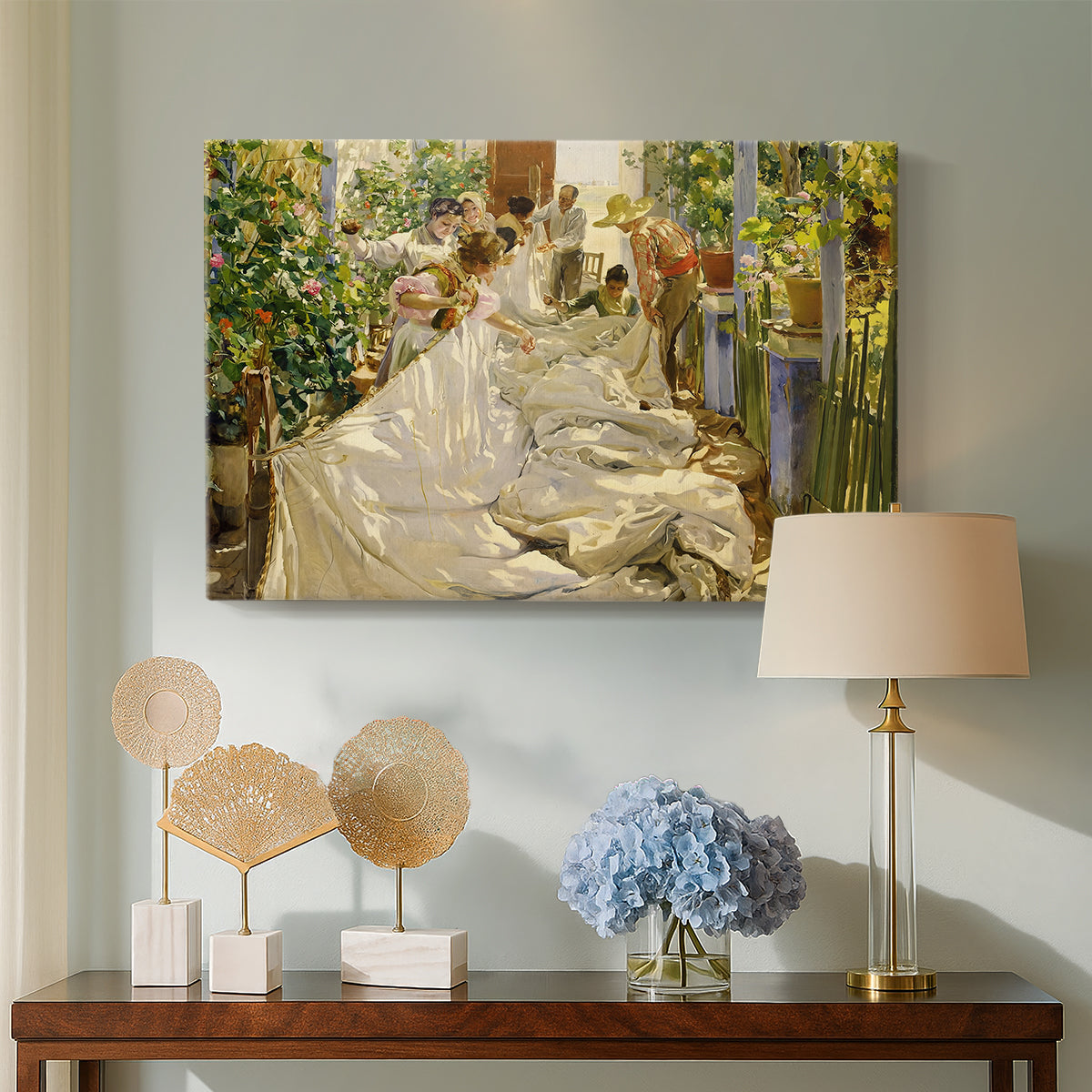 Canvas art print featuring a sunlit composition of workers repairing sailcloth, displayed above a styled console table