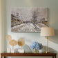 Canvas art print featuring a quiet boulevard blanketed in snow with distant figures, displayed above a styled console table
