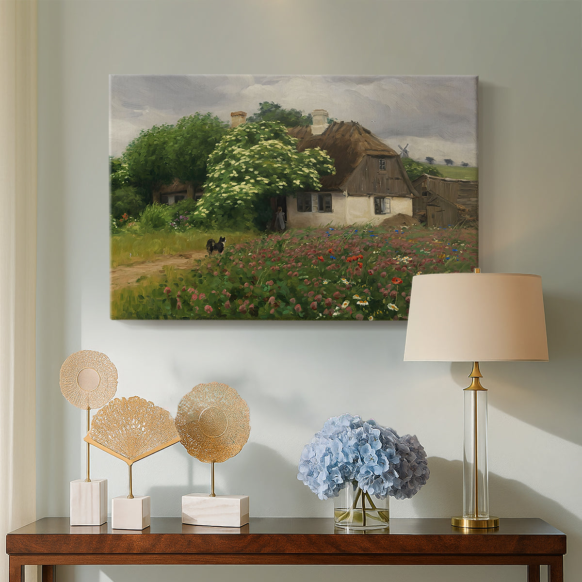 Canvas art print featuring a pastoral scene with house and colorful flowers in field, displayed above a styled console table