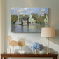 Canvas art print featuring a peaceful canal scene with houses mirrored in water, displayed above a styled console table