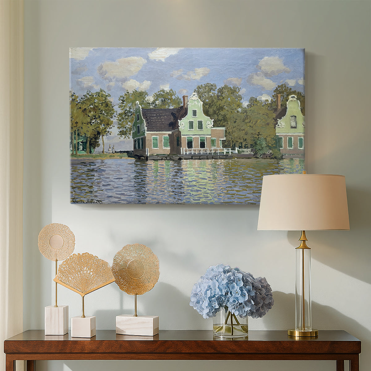 Canvas art print featuring a peaceful canal scene with houses mirrored in water, displayed above a styled console table