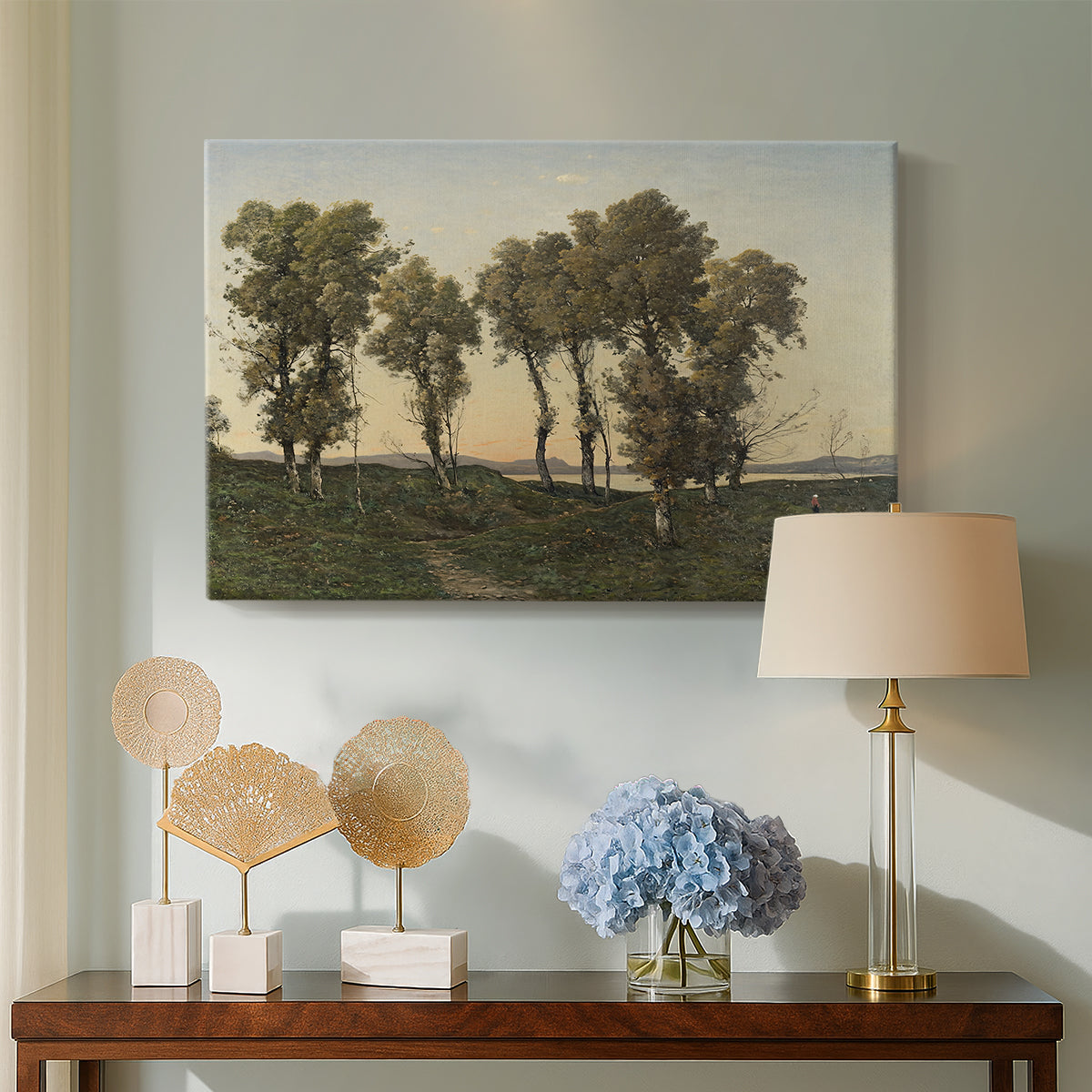 Canvas art print featuring a countryside scene at dusk with trees and soft horizon, displayed above a styled console table