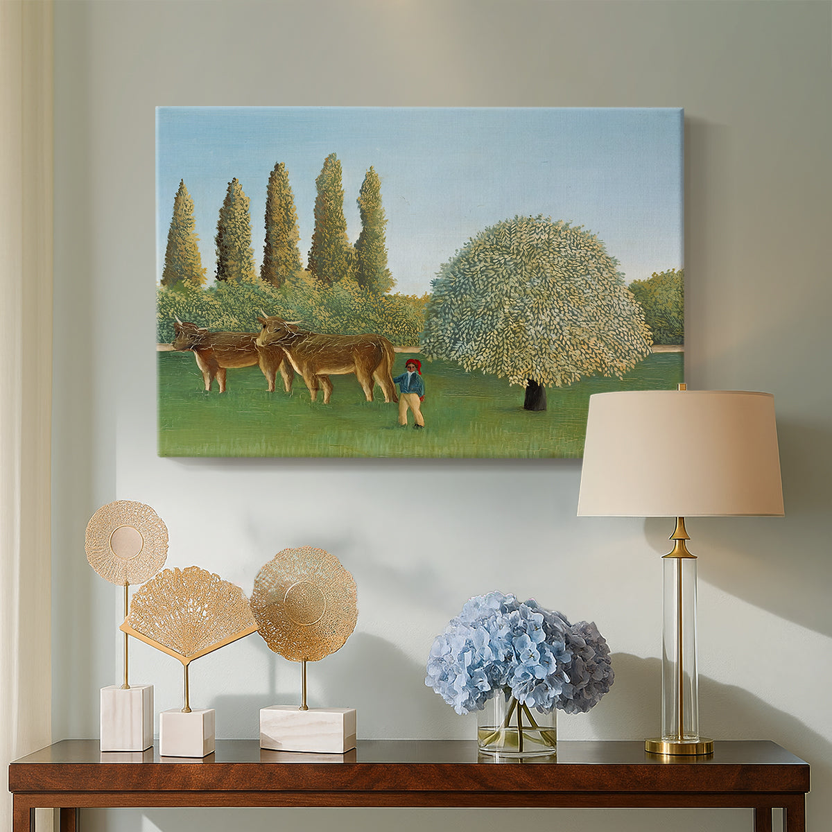Canvas art print featuring a naïve landscape with animals and rolling greenery, displayed above a styled console table