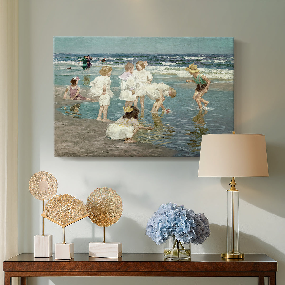 Canvas art print featuring an impressionist coastal view of families enjoying seaside water, displayed above a styled console table