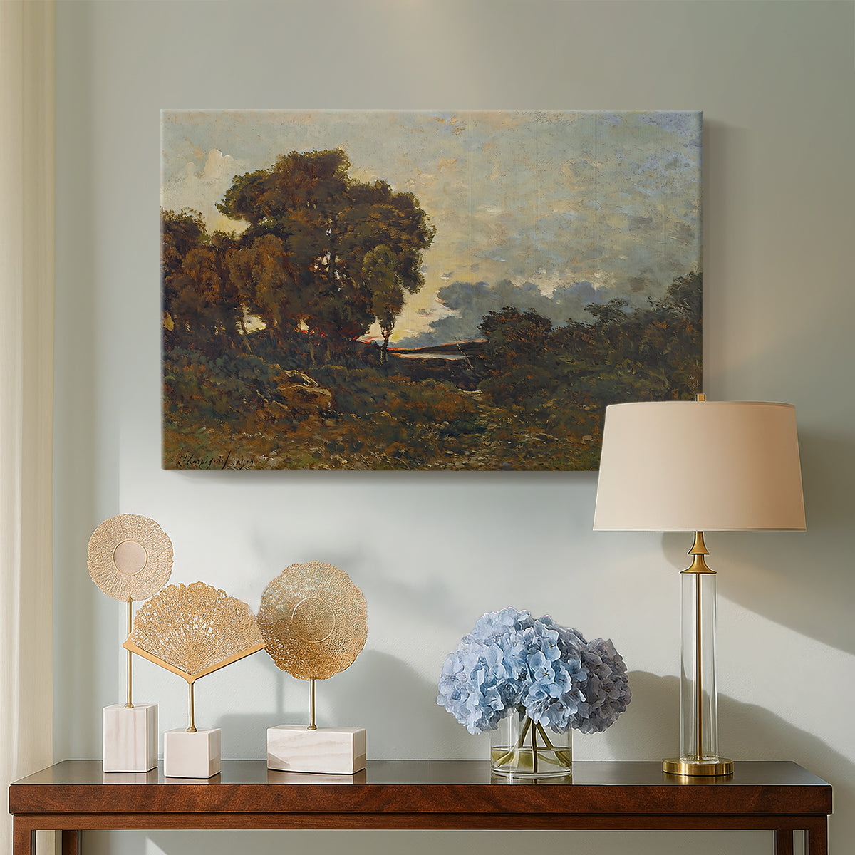 Canvas art print featuring a tranquil sunset view with trees and water, displayed above a styled console table