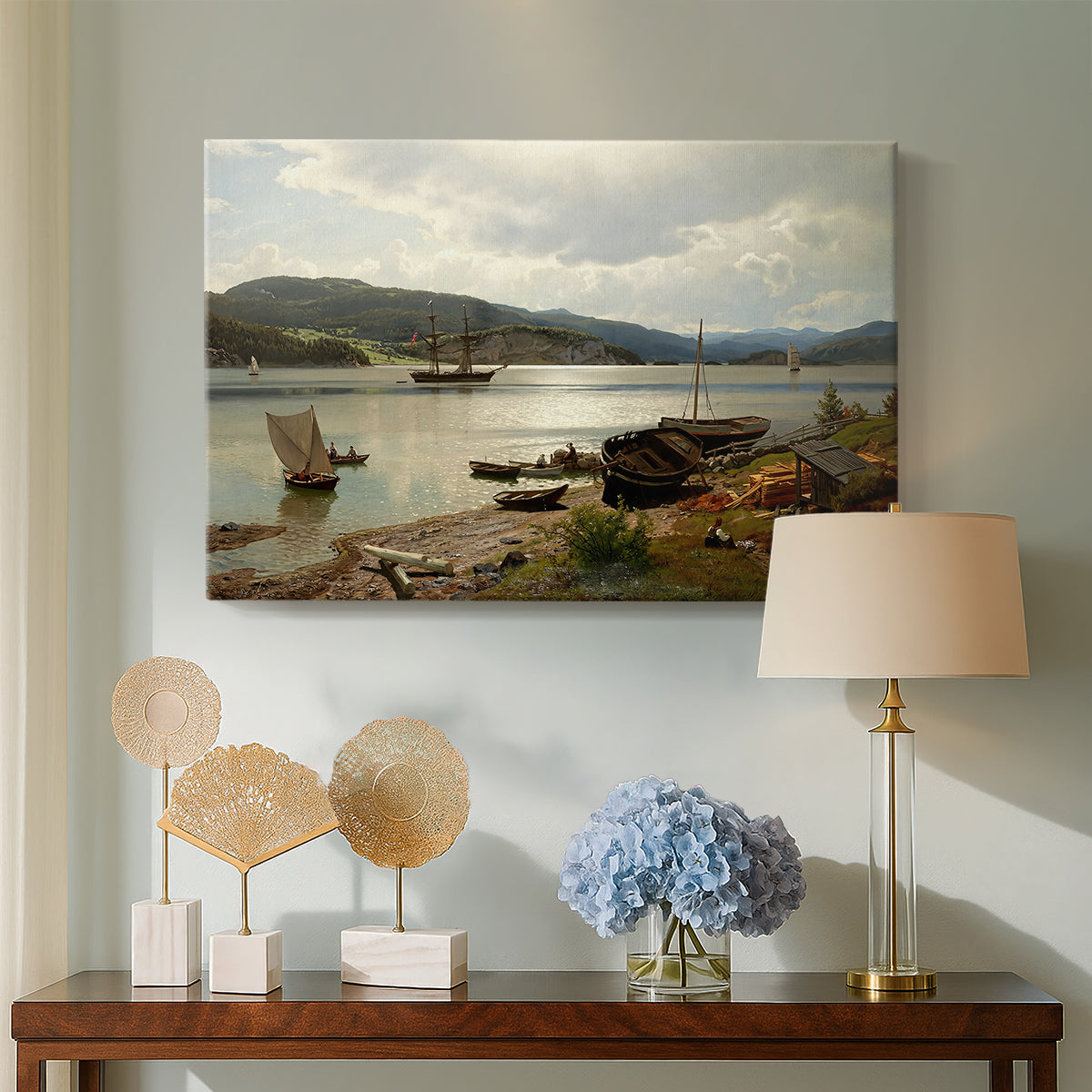 Canvas art print featuring a coastal landscape with figures engaged in daily activity, displayed above a styled console table